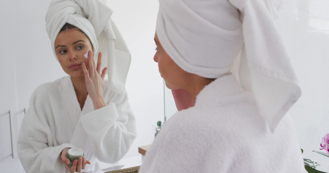 Woman Applying Face Cream in Bathroom Mirror After Shower - Free Images, Stock Photos and Pictures on Pikwizard.com