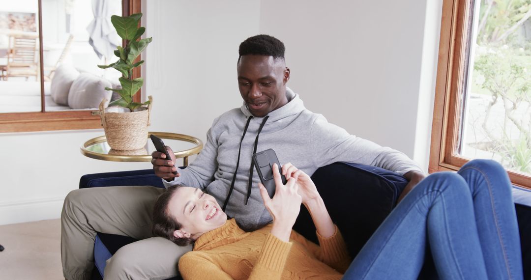 Relaxed Couple Using Smartphones at Cozy Home Lounge