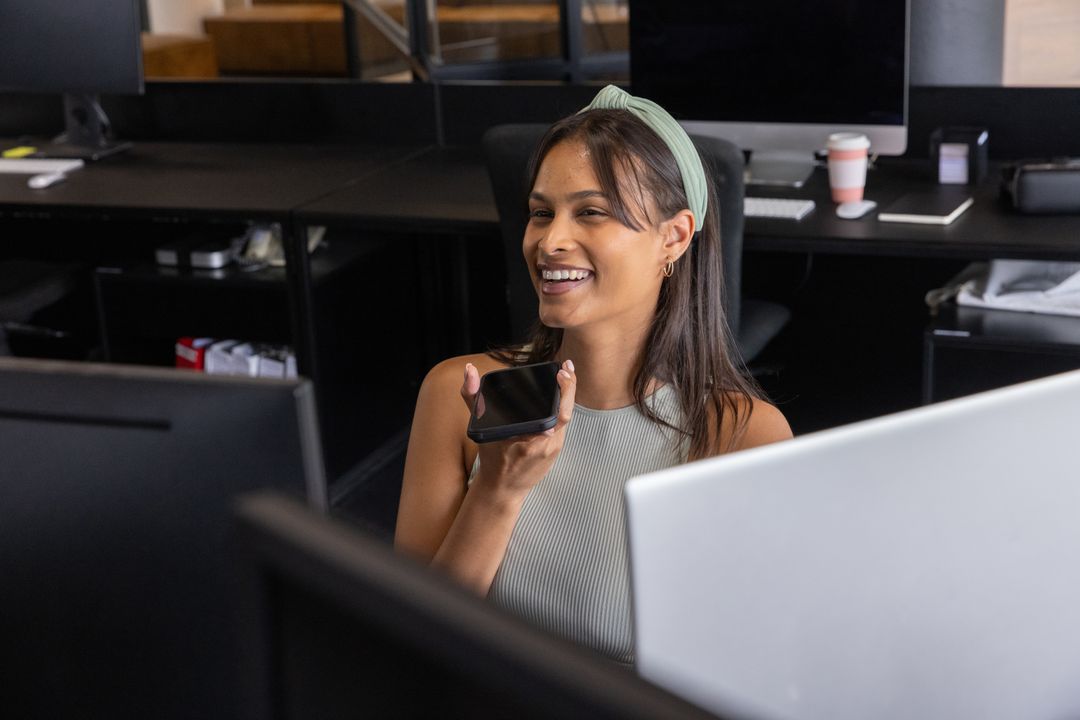 Hispanic Woman Using Voice Command in Modern Office
