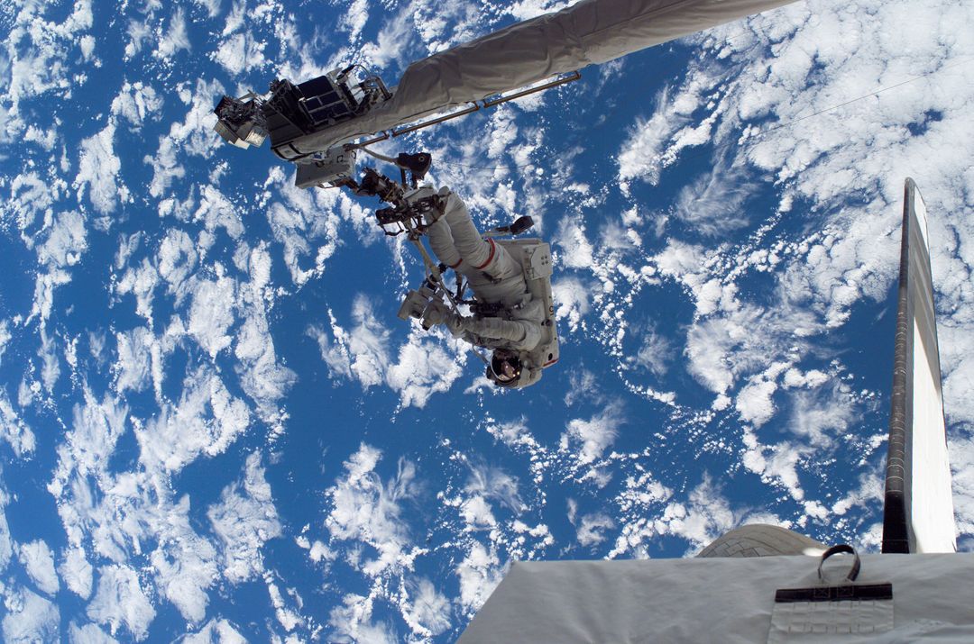 Astronaut Performing Spacewalk During STS-121 Mission over Earth - Free Images, Stock Photos and Pictures on Pikwizard.com