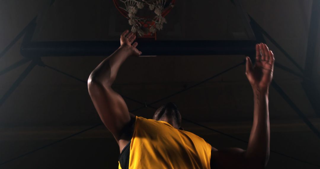Basketball Player Preparing to Shoot in Dark Gymnasium