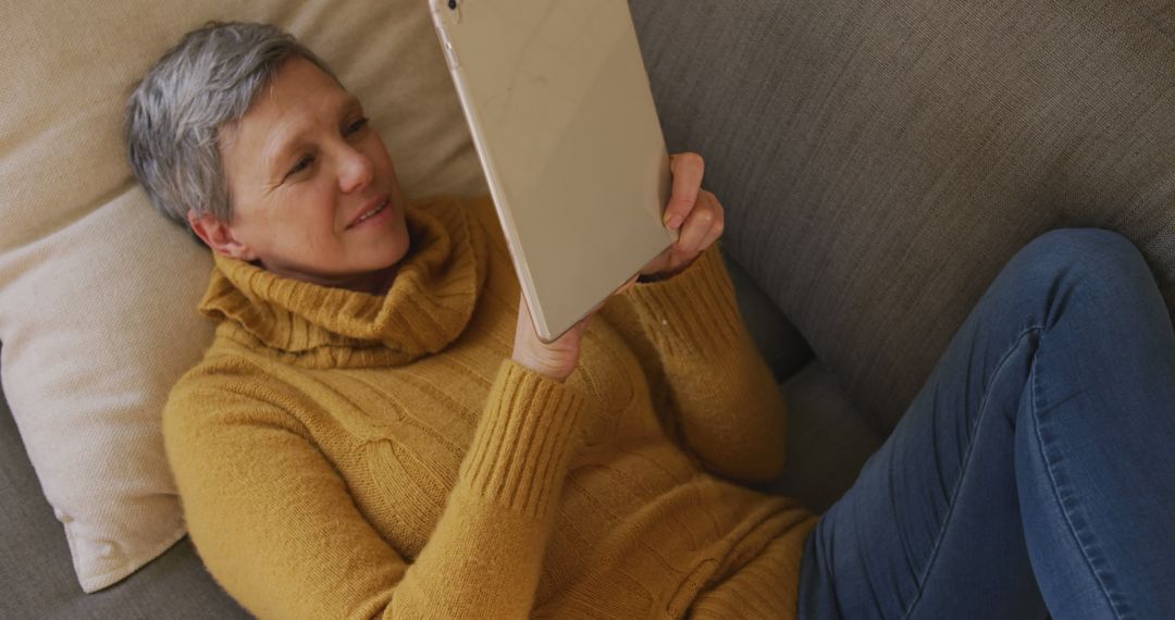 Senior Woman Relaxing on Couch with Tablet Device - Free Images, Stock Photos and Pictures on Pikwizard.com