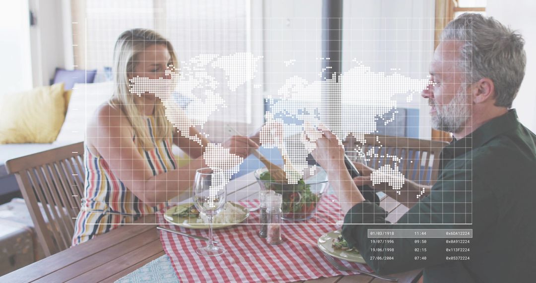 Couple sharing salad at sunlit kitchen table with digital world map overlay