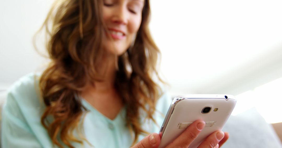 Smiling Woman Using Smartphone in Casual Setting - Free Images, Stock Photos and Pictures on Pikwizard.com