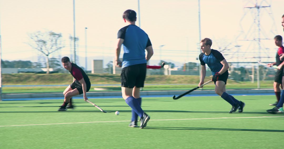 Athletes Competing in Intense Field Hockey Match on Synthetic Turf