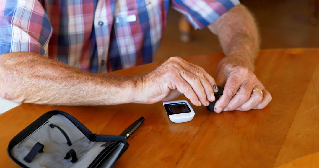 Elderly Man Checking Blood Sugar Levels at Home Table - Free Images, Stock Photos and Pictures on Pikwizard.com