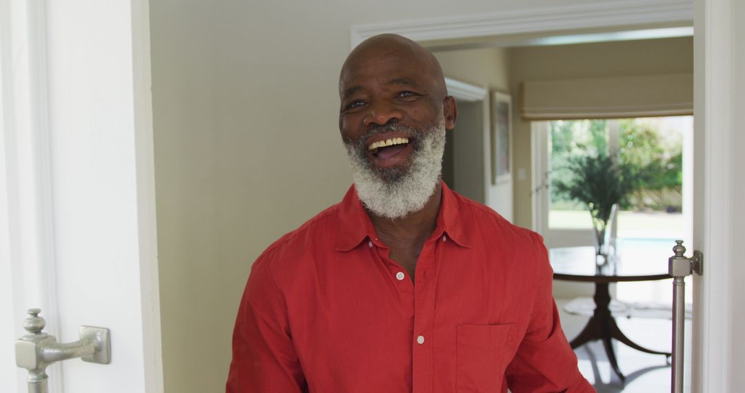 Smiling Older Man Opening Door at Home with Cheerful Expression