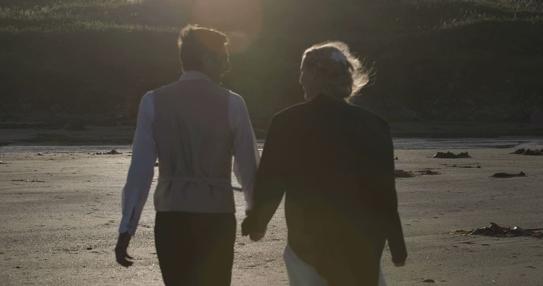 Couple Walking on Beach at Sunset Holding Hands - Free Images, Stock Photos and Pictures on Pikwizard.com