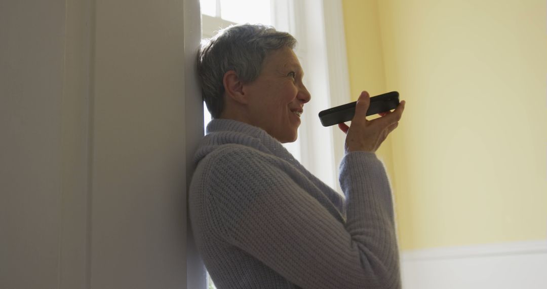 Senior Woman Using Smartphone Voice Assistant in Cozy Home - Free Images, Stock Photos and Pictures on Pikwizard.com