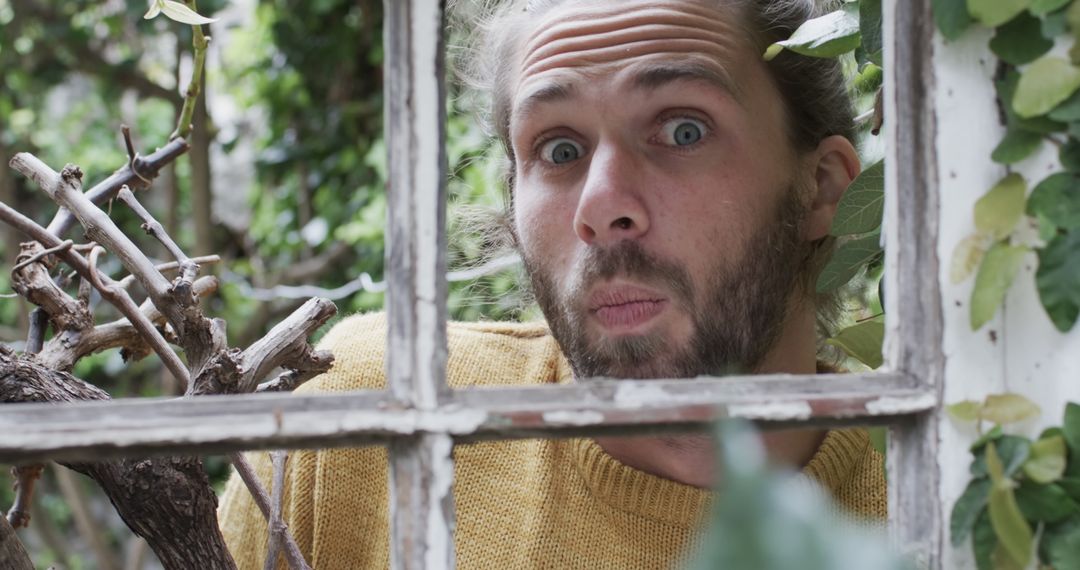 Surprised Man Looking Through Window Pane in Garden - Free Images, Stock Photos and Pictures on Pikwizard.com