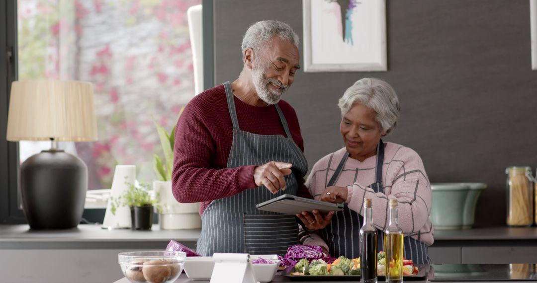 Senior Couple Cooking Together and Using Tablet in Modern Kitchen