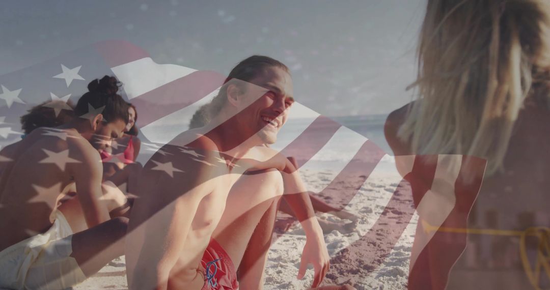 Smiling man in red swim trunks sitting with friends on beach with American flag overlay