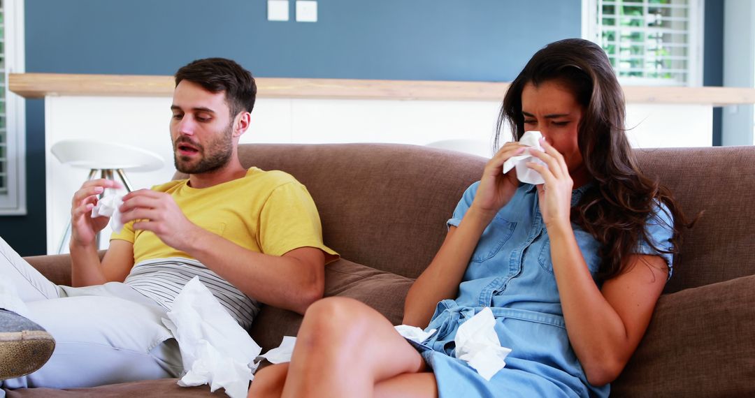 Couple Battling Allergies on Sofa Using Tissues Together