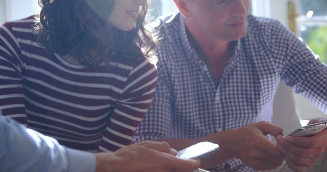 Casual Discussion Over Smartphone in Relaxed Bright Environment