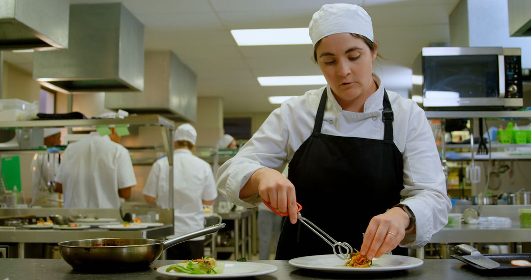 Female chef plating gourmet dish in professional kitchen - Free Images, Stock Photos and Pictures on Pikwizard.com