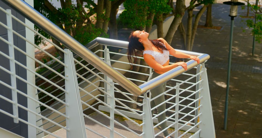 Woman Enjoying Sunshine on Modern Stairwell - Free Images, Stock Photos and Pictures on Pikwizard.com