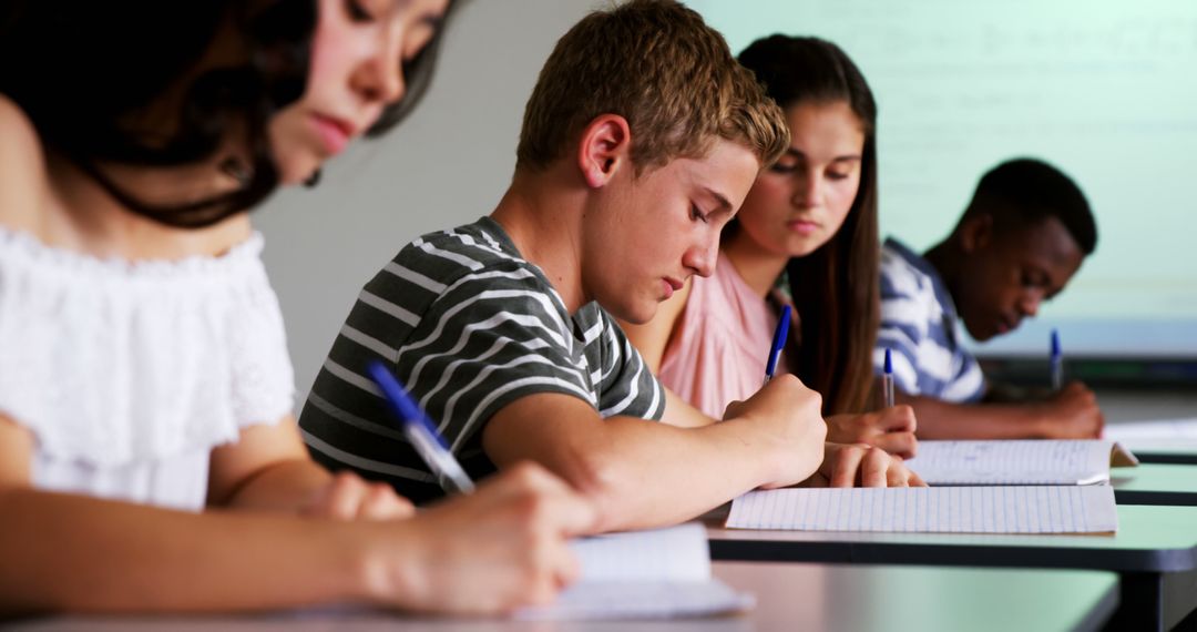 Diverse Students Focused on Writing Notes in Classroom
