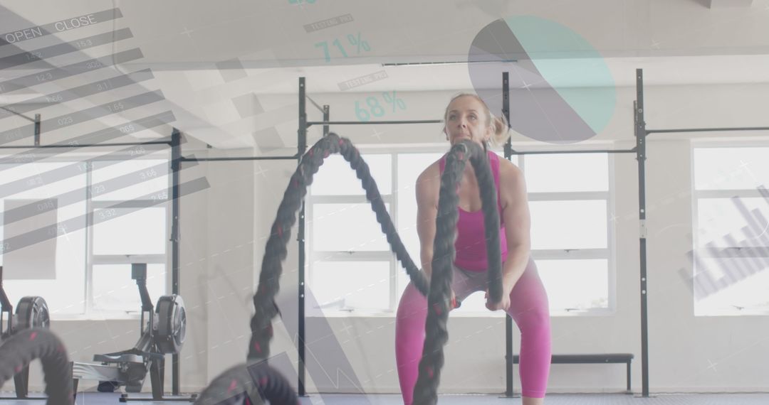 Woman Intense Cross Training with Battle Ropes in Gym