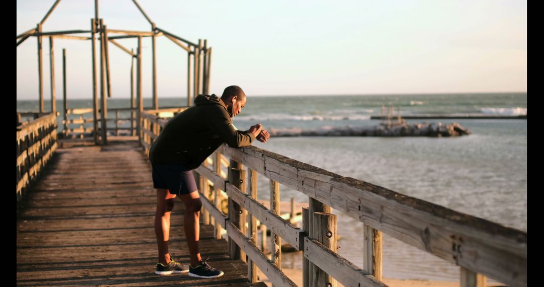 Man Cooling Down After Jog on Beach Pier with Ocean View