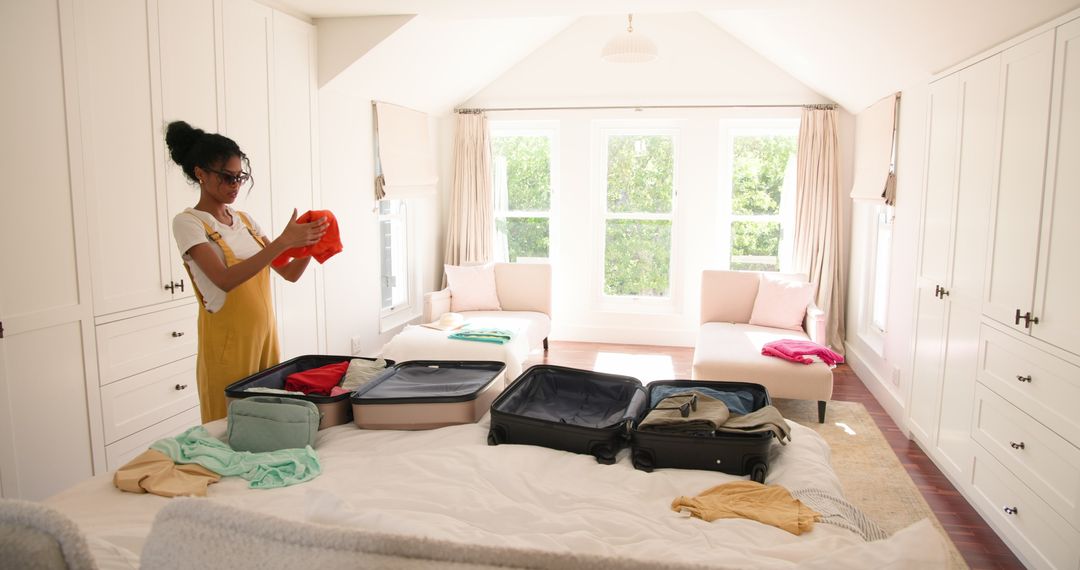 Woman Preparing Clothes in Sunny Home Bedroom for Travel