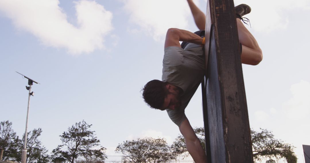 Determined Man Overcoming Obstacle Wall at Outdoor Training - Free Images, Stock Photos and Pictures on Pikwizard.com