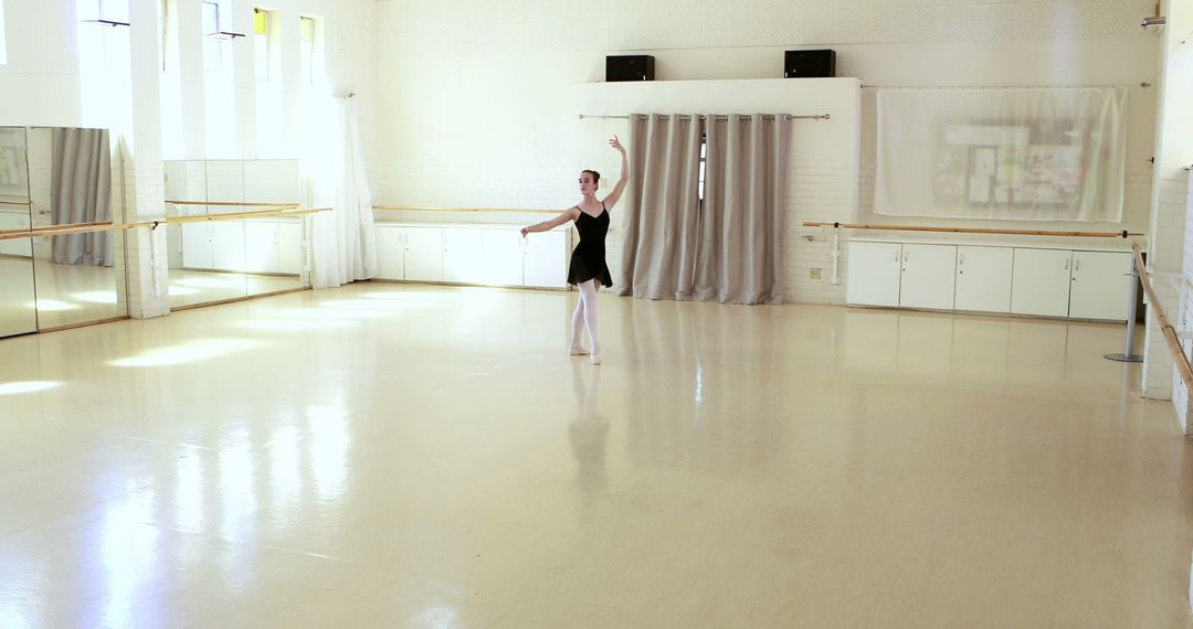 Solo ballerina practicing gracefully in a bright dance studio - Free Images, Stock Photos and Pictures on Pikwizard.com