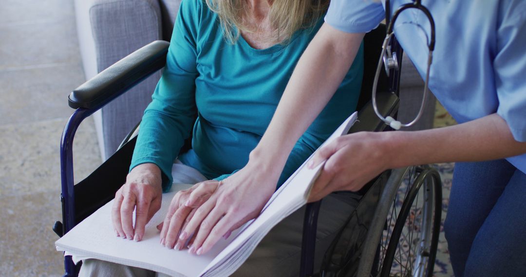 Elderly Woman in Wheelchair Learning Braille with Nurse's Assistance - Free Images, Stock Photos and Pictures on Pikwizard.com