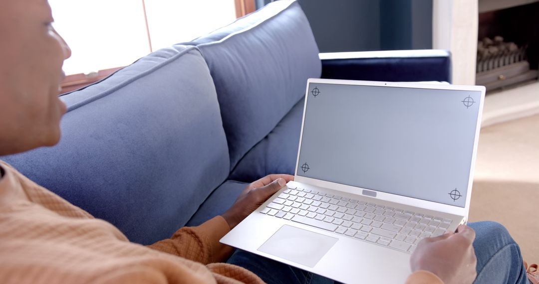 Man using blank screen laptop seated on couch in home living room - Free Images, Stock Photos and Pictures on Pikwizard.com