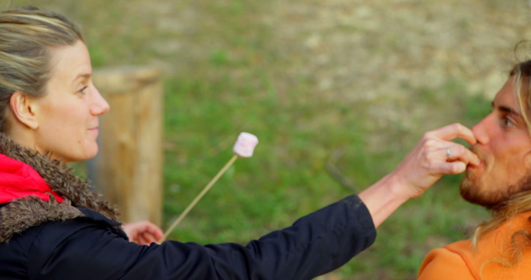 Couple Roasting Marshmallows Together at Campfire
