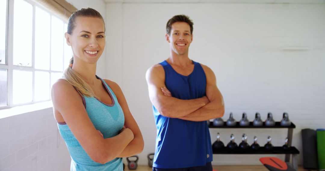 Smiling Fitness Trainers Standing with Arms Crossed in Gym - Free Images, Stock Photos and Pictures on Pikwizard.com