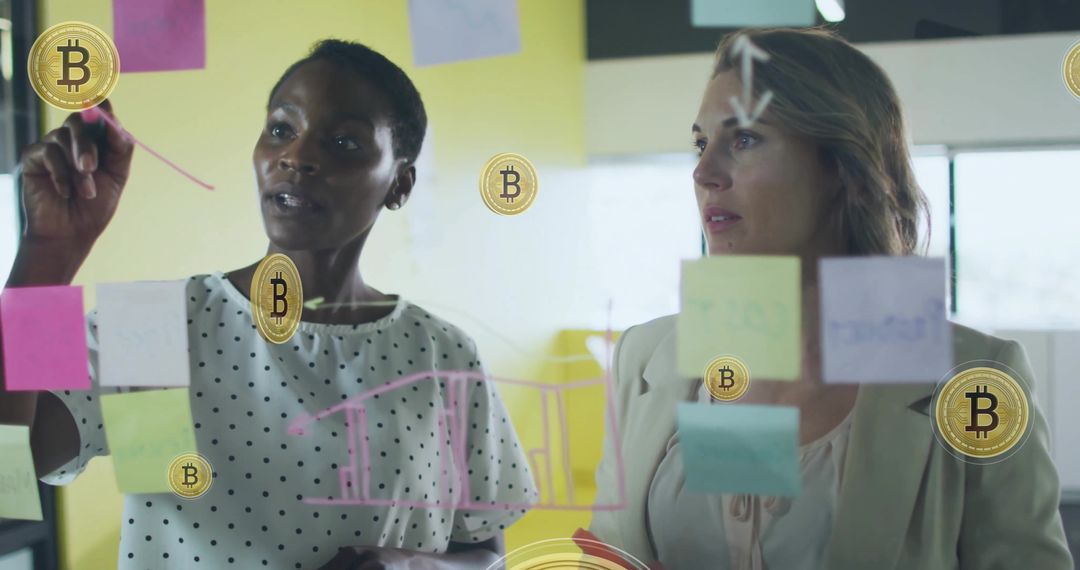Two Women Collaborating on Bitcoin Strategy Using Glass Board and Colorful Sticky Notes