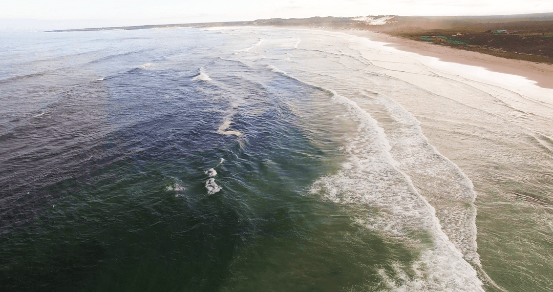 Transparent Ocean Waves Gently Crashing on Serene Beach Shoreline