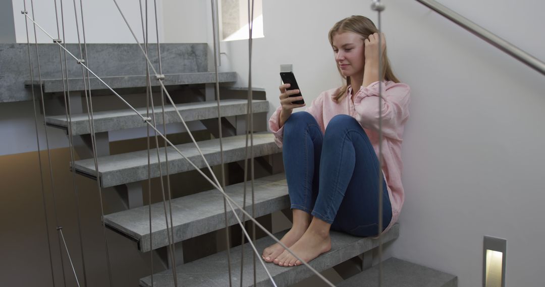 Young Woman Sitting on Modern Staircase Using Smartphone - Free Images, Stock Photos and Pictures on Pikwizard.com