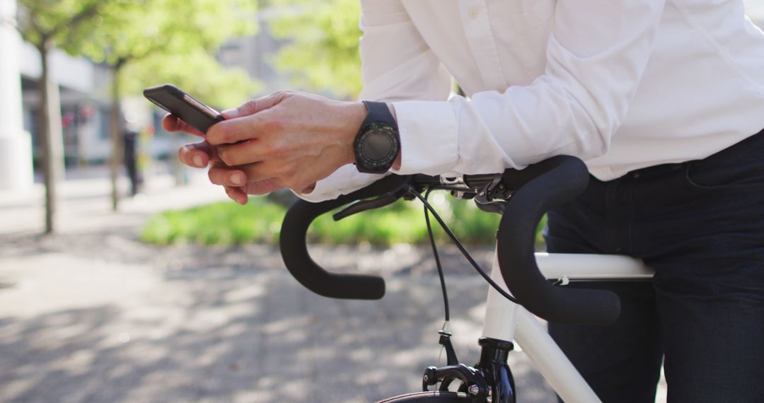 Businessman Checking Smartphone While Leaning on Bicycle - Free Images, Stock Photos and Pictures on Pikwizard.com