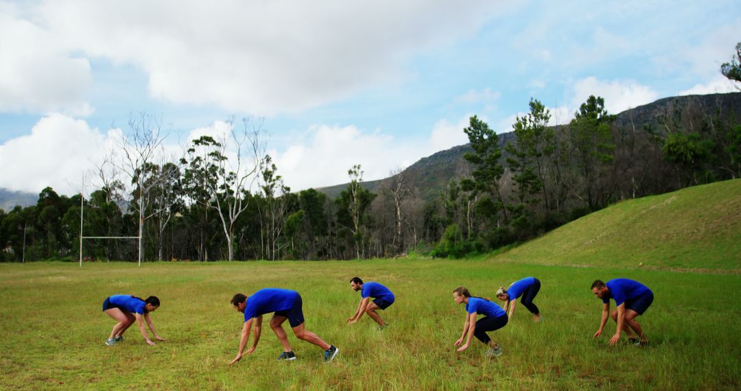 Team Exercise in Green Field with Mountains - Free Images, Stock Photos and Pictures on Pikwizard.com