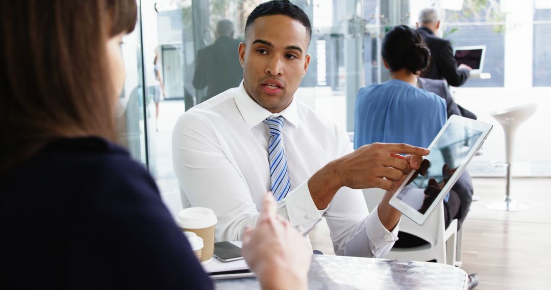 Businessman Discussing Digital Tablet in Modern Office Cafe