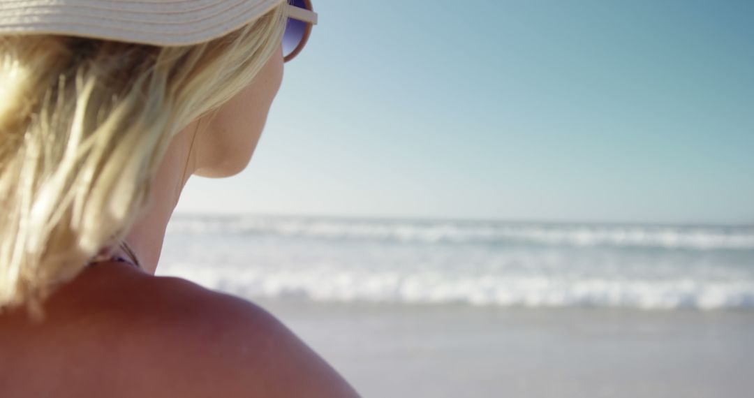 Relaxed Woman Enjoying Ocean View with Sunhat and Sunglasses - Free Images, Stock Photos and Pictures on Pikwizard.com