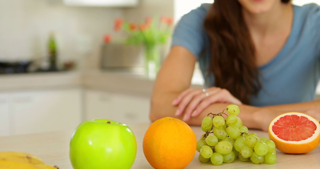 Woman Enjoying Fresh Fruit Selection in Modern Kitchen - Free Images, Stock Photos and Pictures on Pikwizard.com