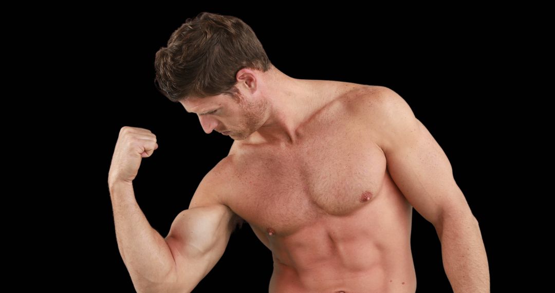 Muscular Man Flexing Bicep Against Black Background - Free Images, Stock Photos and Pictures on Pikwizard.com