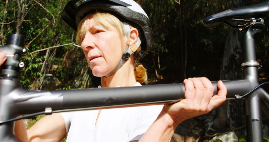 Focused Senior Woman Preparing Bicycle for Mountain Trail - Free Images, Stock Photos and Pictures on Pikwizard.com