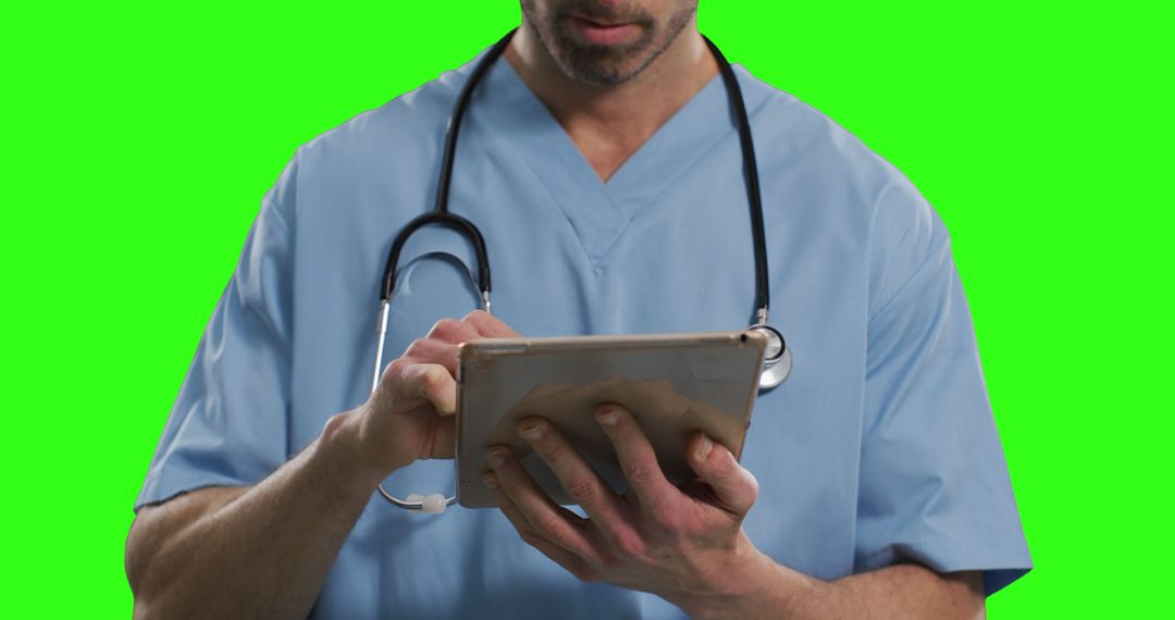 Doctor in Scrubs Using Tablet on Green Screen Background - Free Images, Stock Photos and Pictures on Pikwizard.com