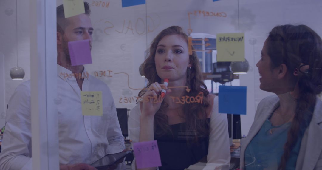 Business Team Brainstorming with Sticky Notes on Glass Walls