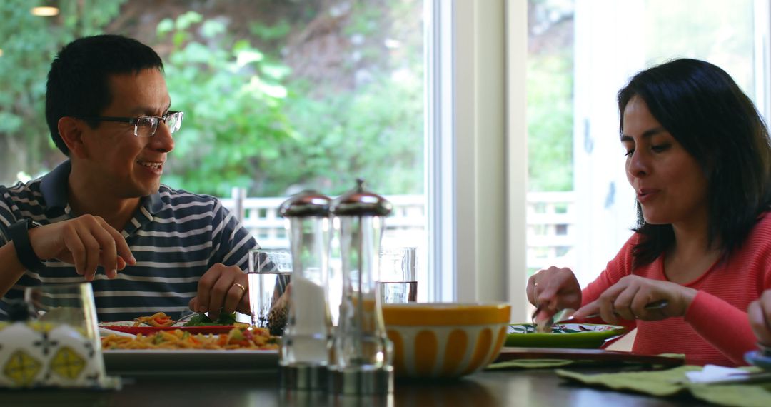 Smiling Biracial Couple Dining Relaxed at Home