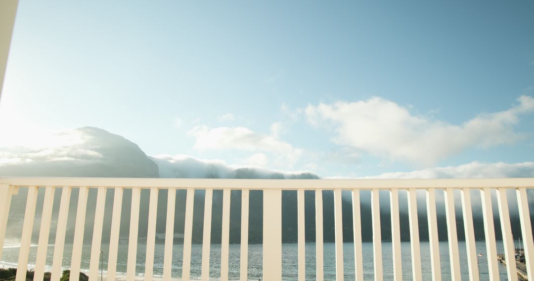 Tranquil lakeside balcony view with mountains and sky
