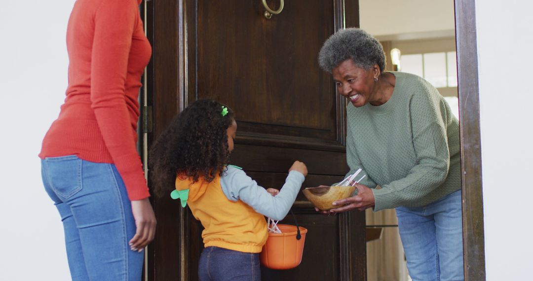 Senior Woman Greeting Child with Halloween Treats at Front Door - Free Images, Stock Photos and Pictures on Pikwizard.com