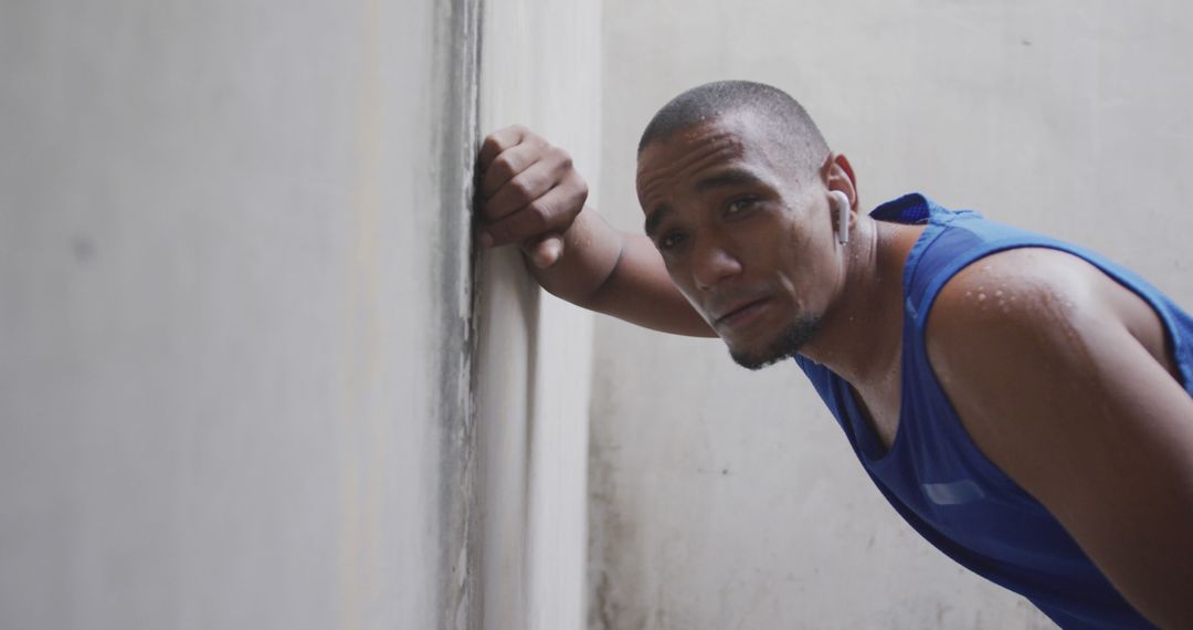 Exhausted Athlete Resting Against Wall After Intense Workout - Free Images, Stock Photos and Pictures on Pikwizard.com