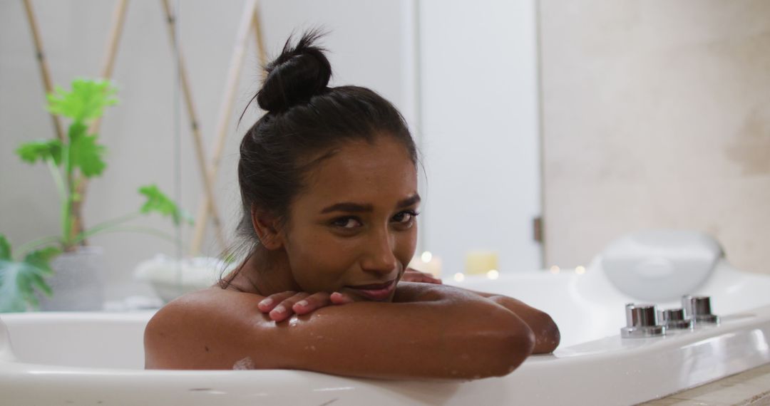 Young Woman Relaxing in Bathtub with Green Plants and Candles - Free Images, Stock Photos and Pictures on Pikwizard.com