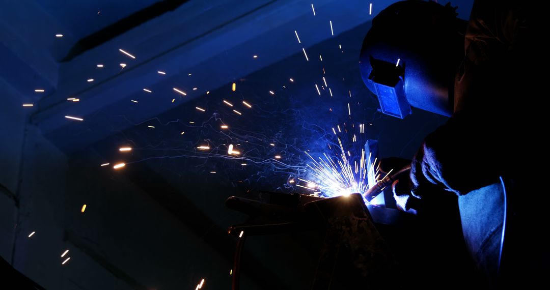 Industrial Worker Welding in Dark Workshop - Free Images, Stock Photos and Pictures on Pikwizard.com