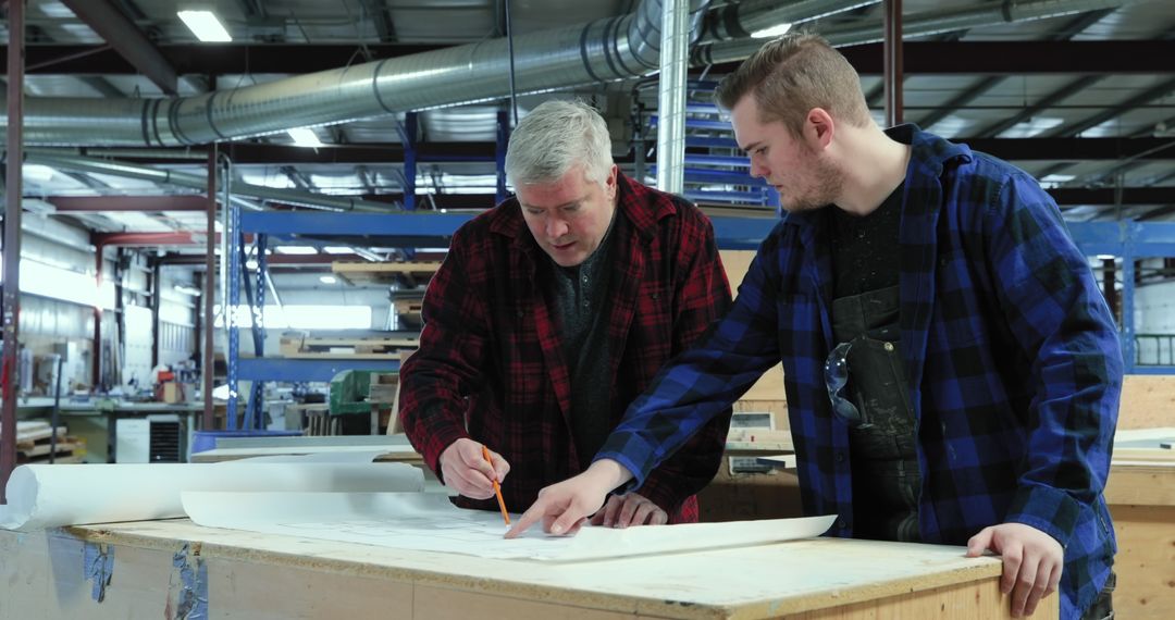 Caucasian Men Collaborating on Plans in Industrial Workshop - Free Images, Stock Photos and Pictures on Pikwizard.com