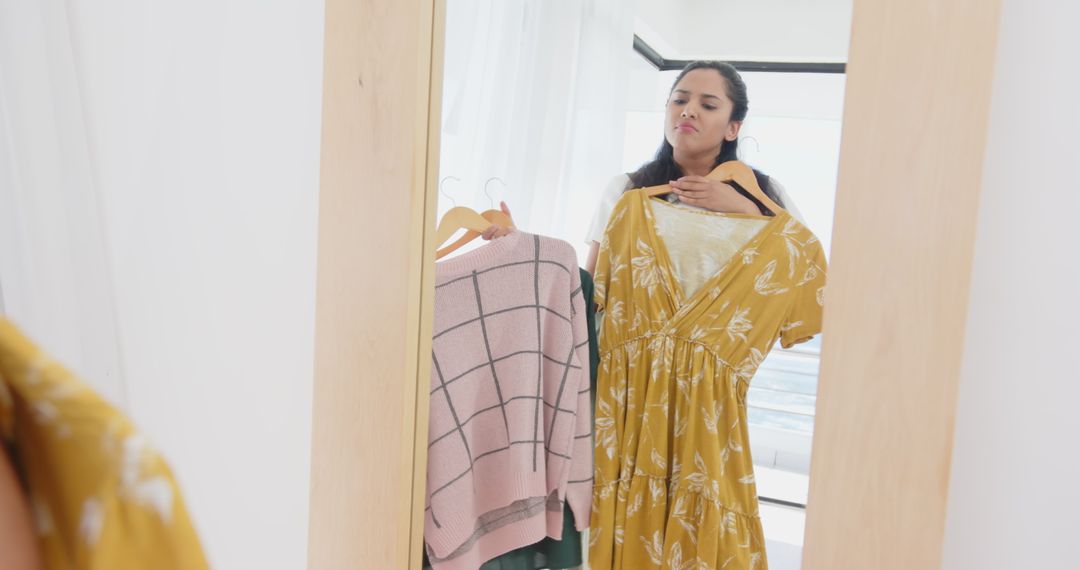 Asian Woman Deciding Between Floral Dress and Checkered Sweater